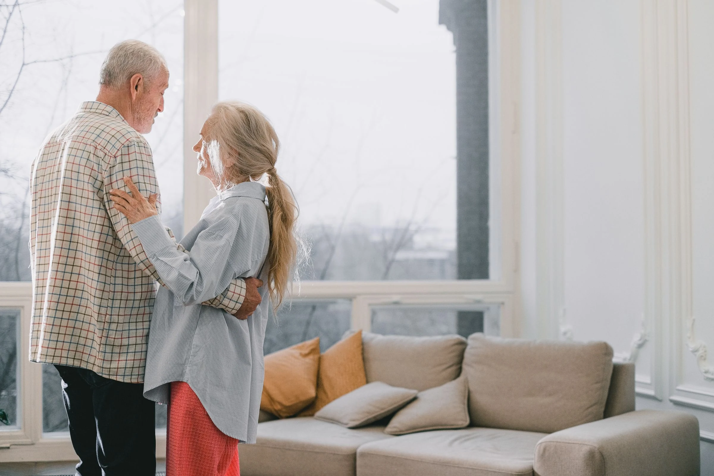 An older couple dancing together at home